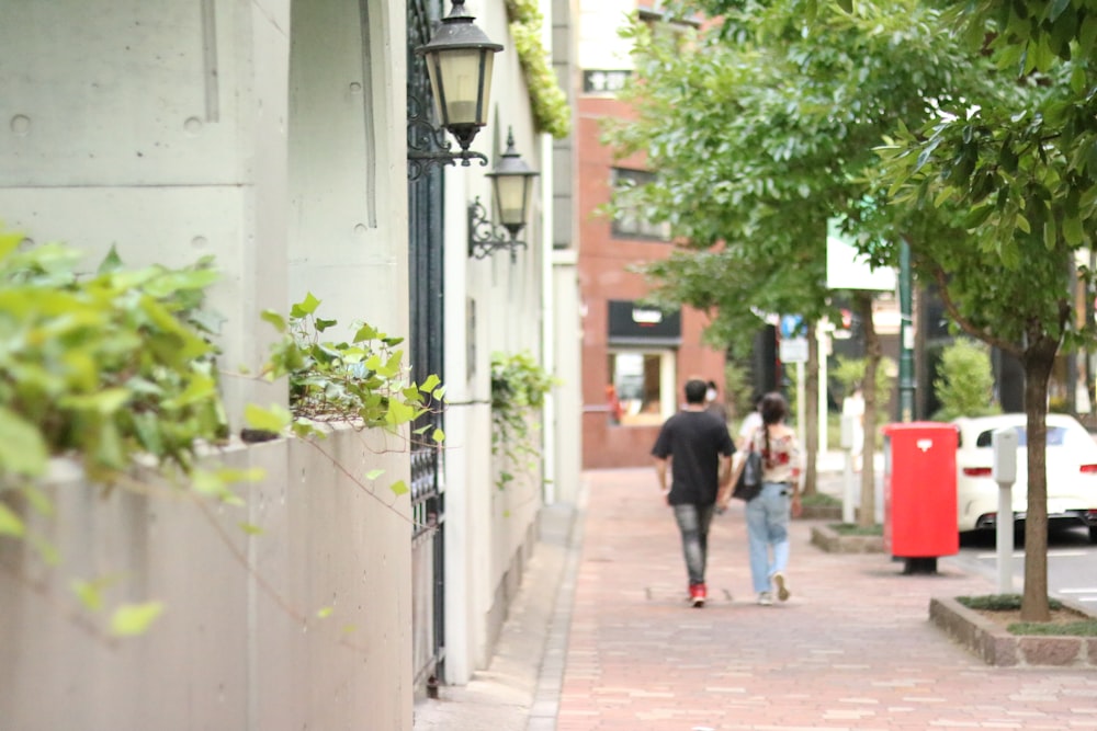 man in black jacket walking on sidewalk during daytime