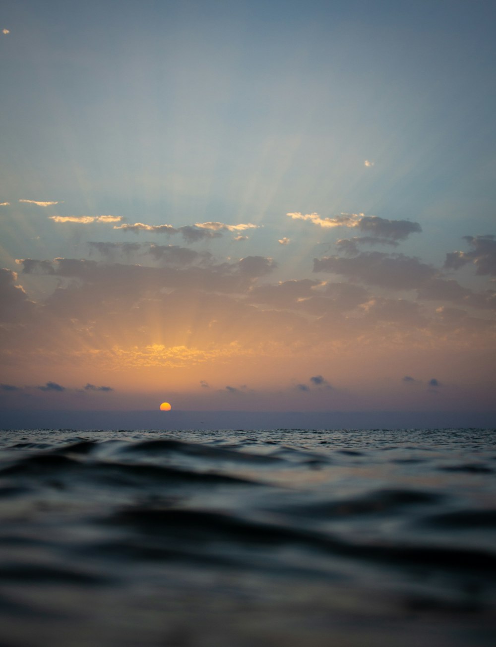 corpo d'acqua sotto cielo nuvoloso durante il tramonto