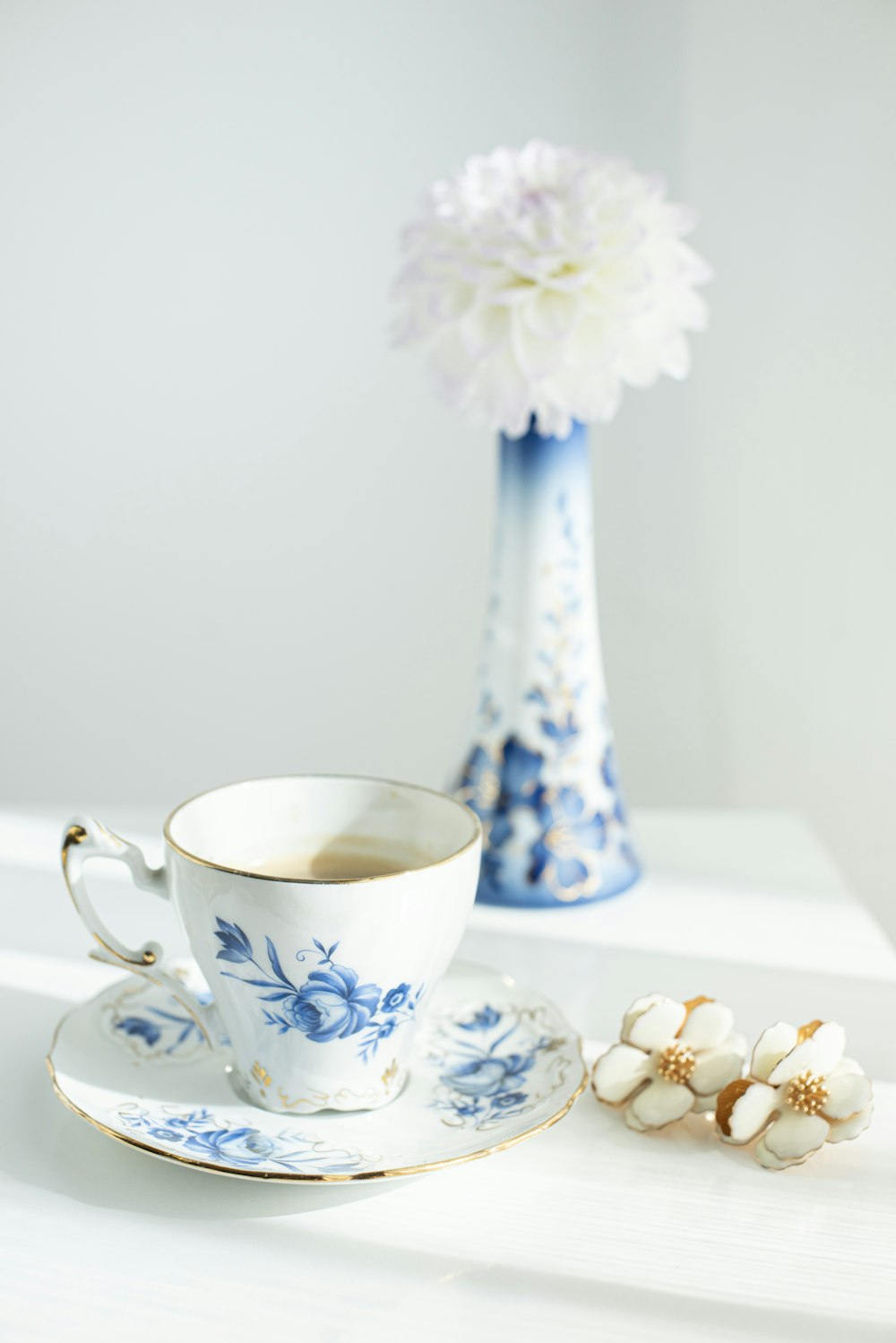 white and blue floral ceramic teacup on saucer