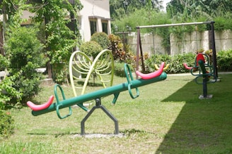 A peaceful green playground area where children and elders enjoy the sunshine and rest.