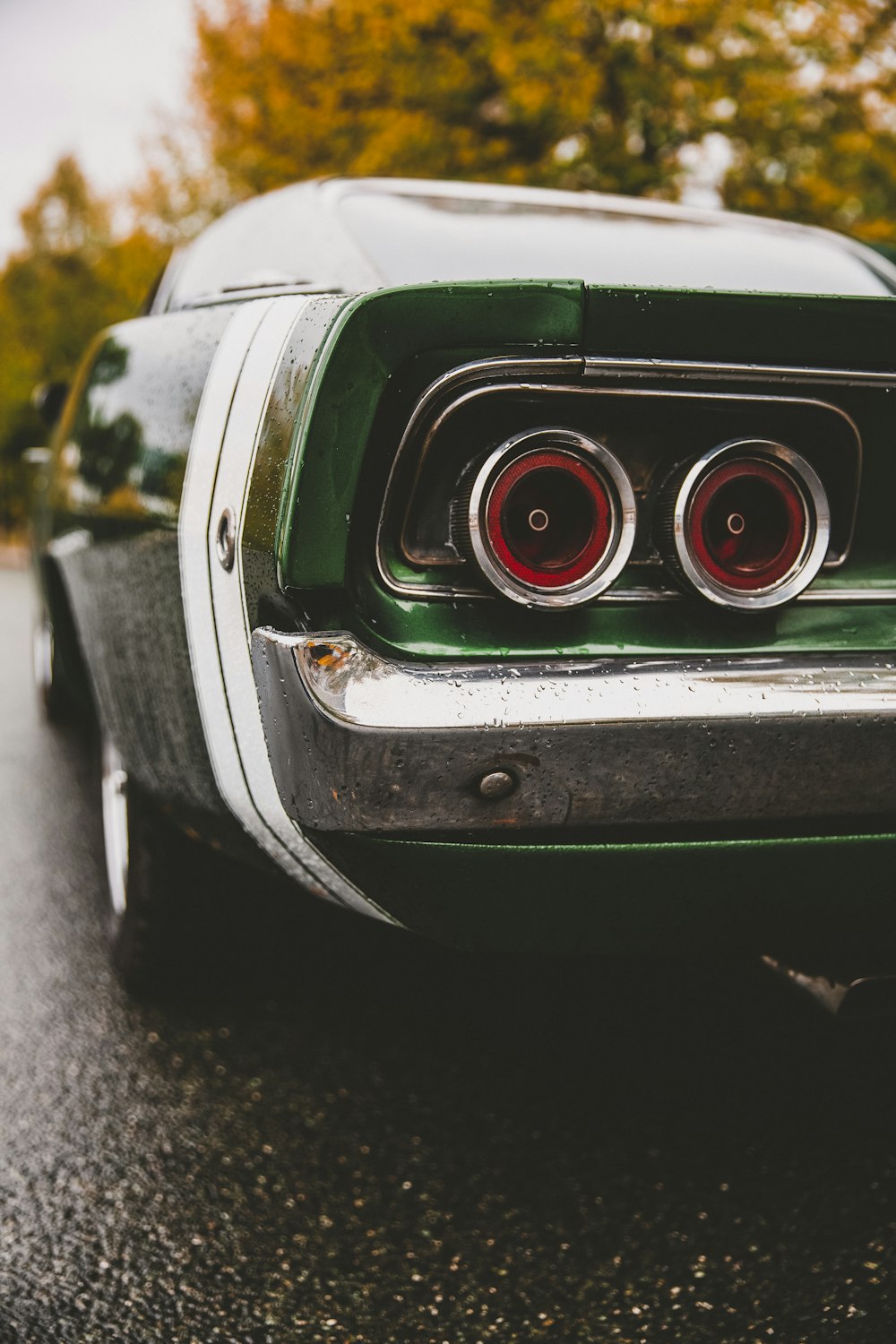 昼間の道路を走る緑と白の車