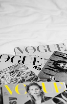 a pile of magazines sitting on top of a bed