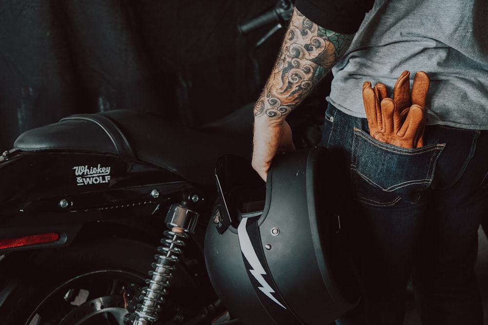 person in brown jacket and blue denim jeans riding on motorcycle