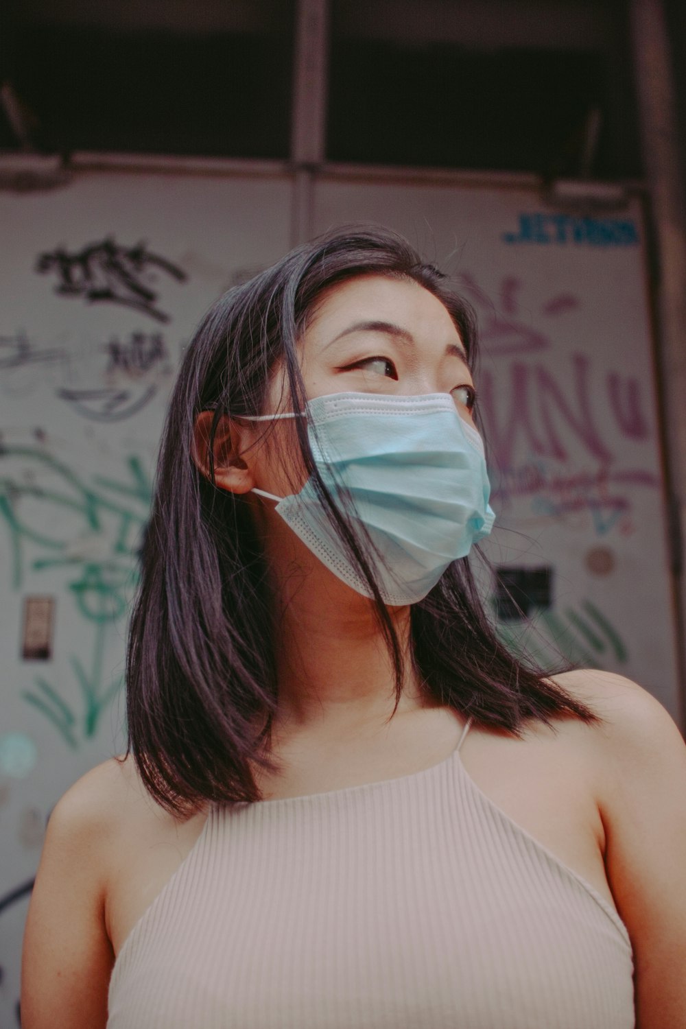 woman in white tank top with face mask