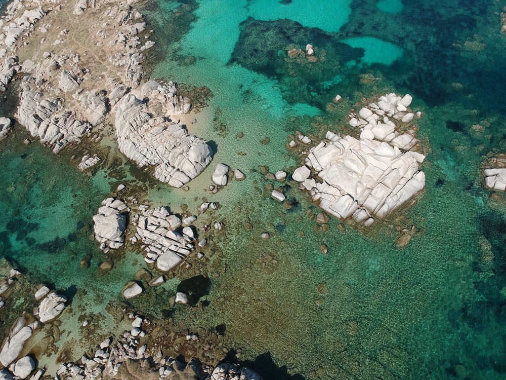aerial view of white and gray rocks on body of water during daytime