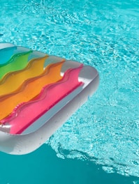 red yellow and green inflatable pool float on swimming pool