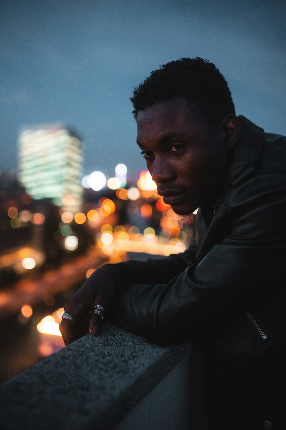 man in black leather jacket holding lighted candle