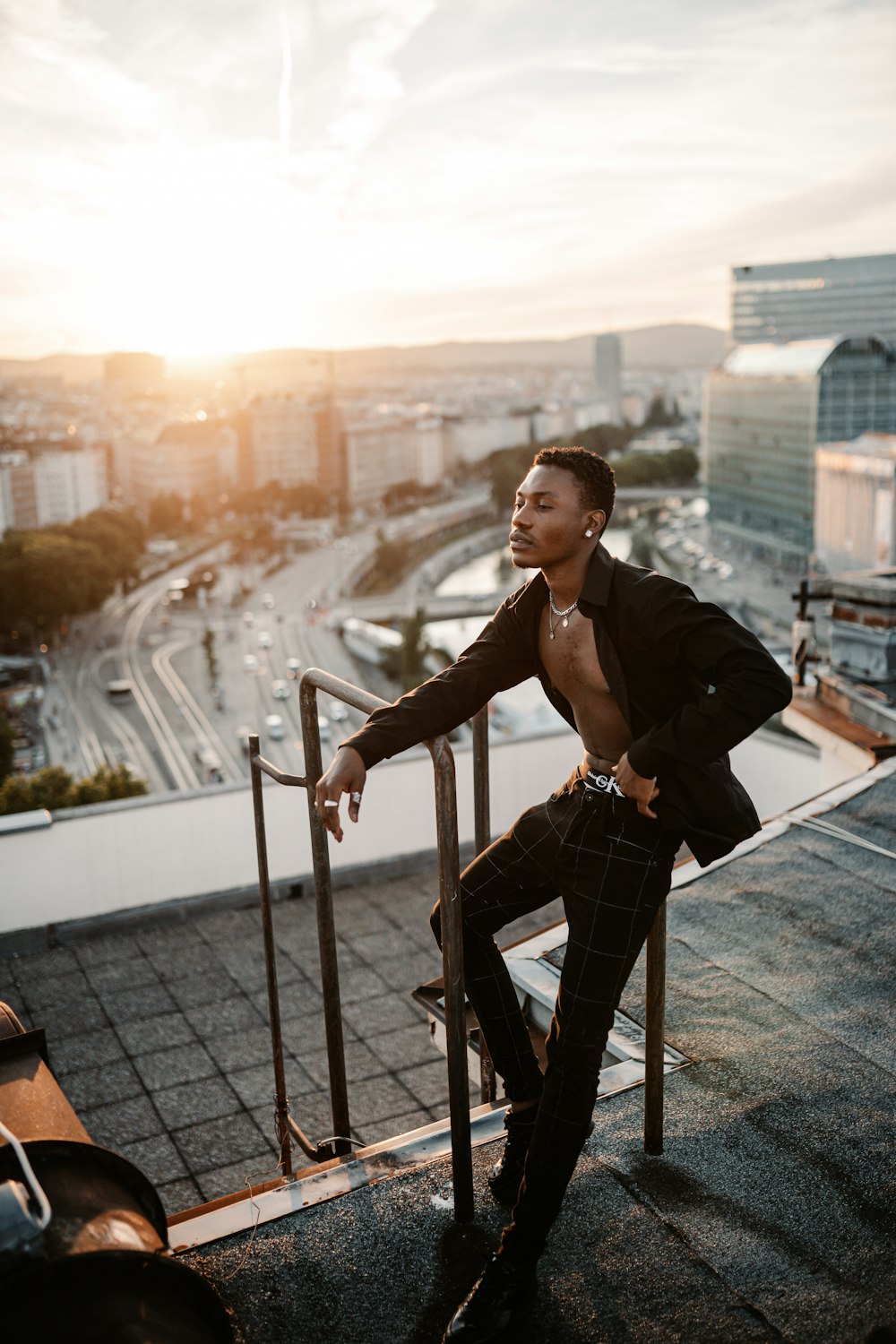 man in black jacket and black pants standing on gray metal railings during daytime