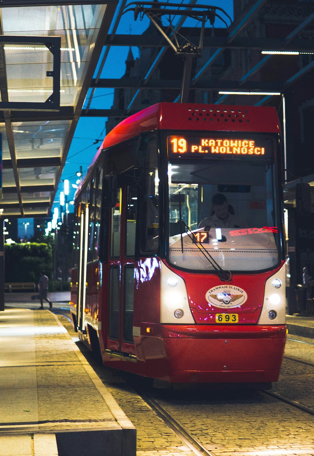 red and white tram on road during night time