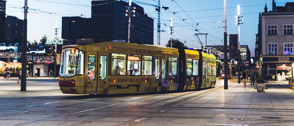 yellow and white tram on road during night time