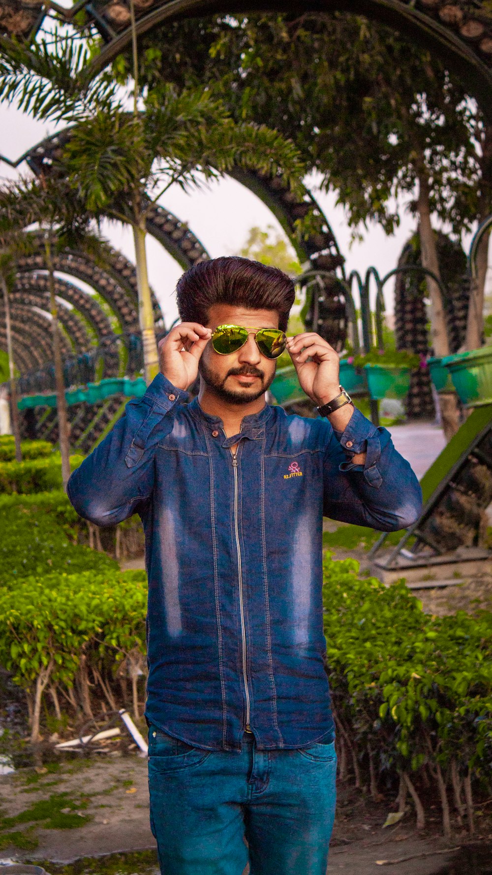 man in blue denim jacket wearing green sunglasses