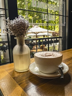 A sunlit Parisian balcony adorned with blooming lavender and a delicate cup of coffee resting on a wrought-iron table.