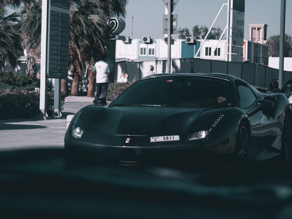 Porsche 911 noire garée dans la rue pendant la journée