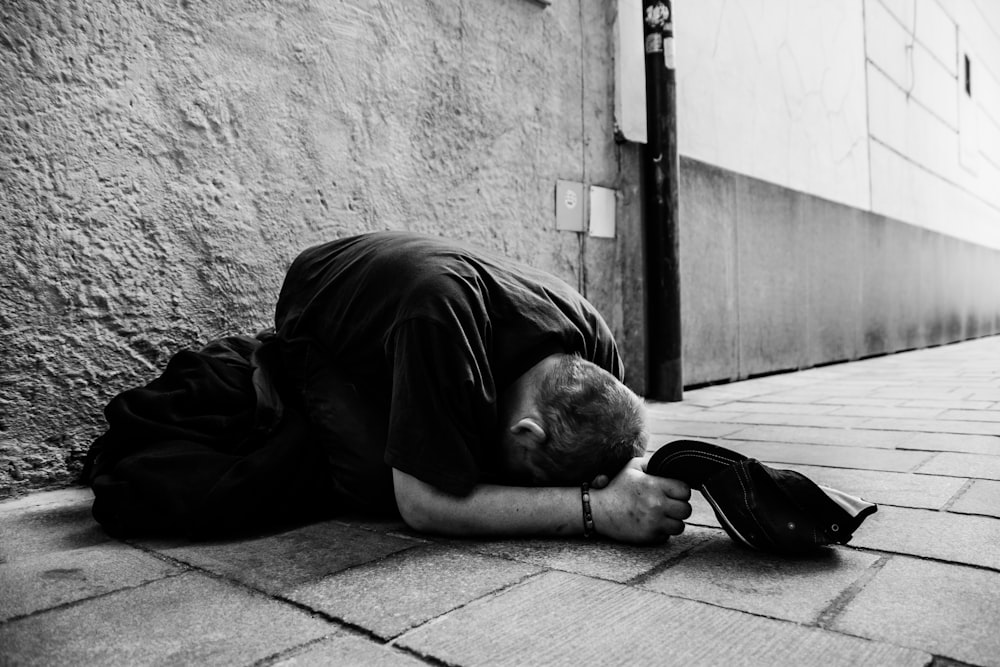 man in black jacket lying on floor