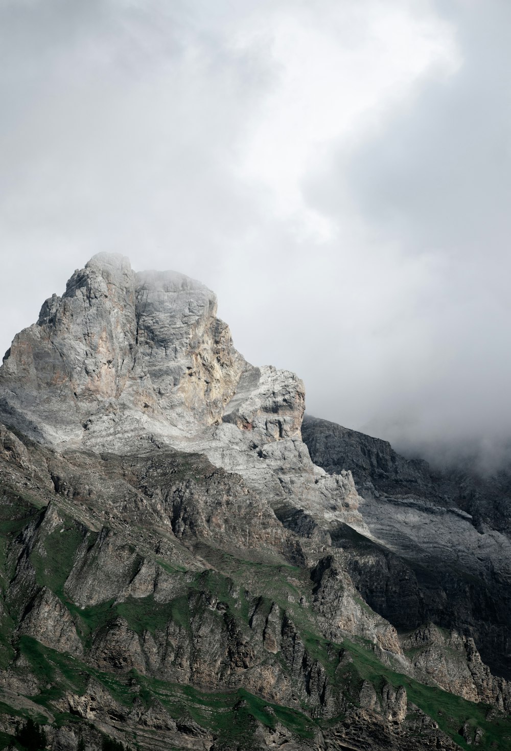 montagna rocciosa grigia sotto il cielo bianco durante il giorno