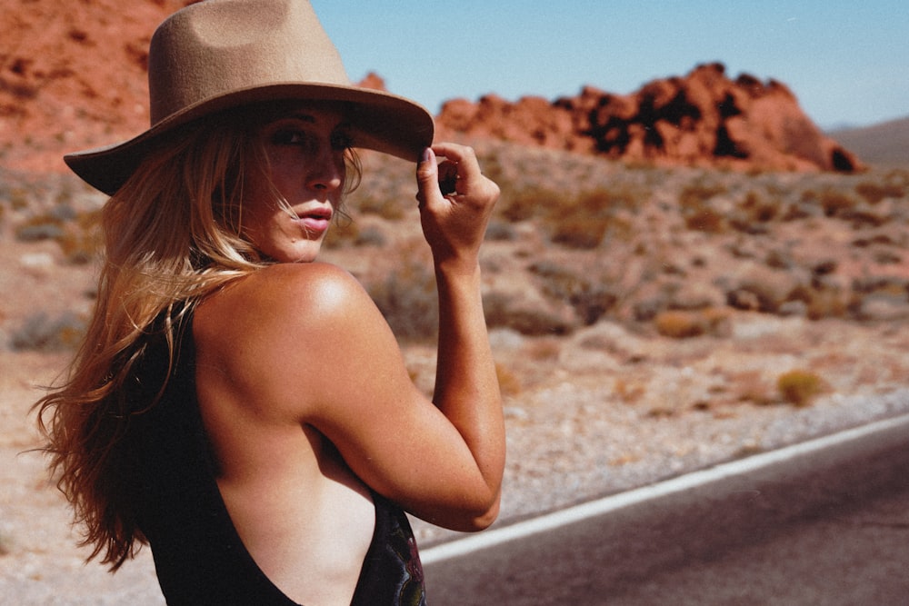 woman in black tank top wearing brown fedora hat