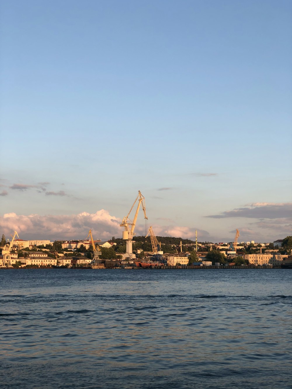 body of water near city buildings during sunset