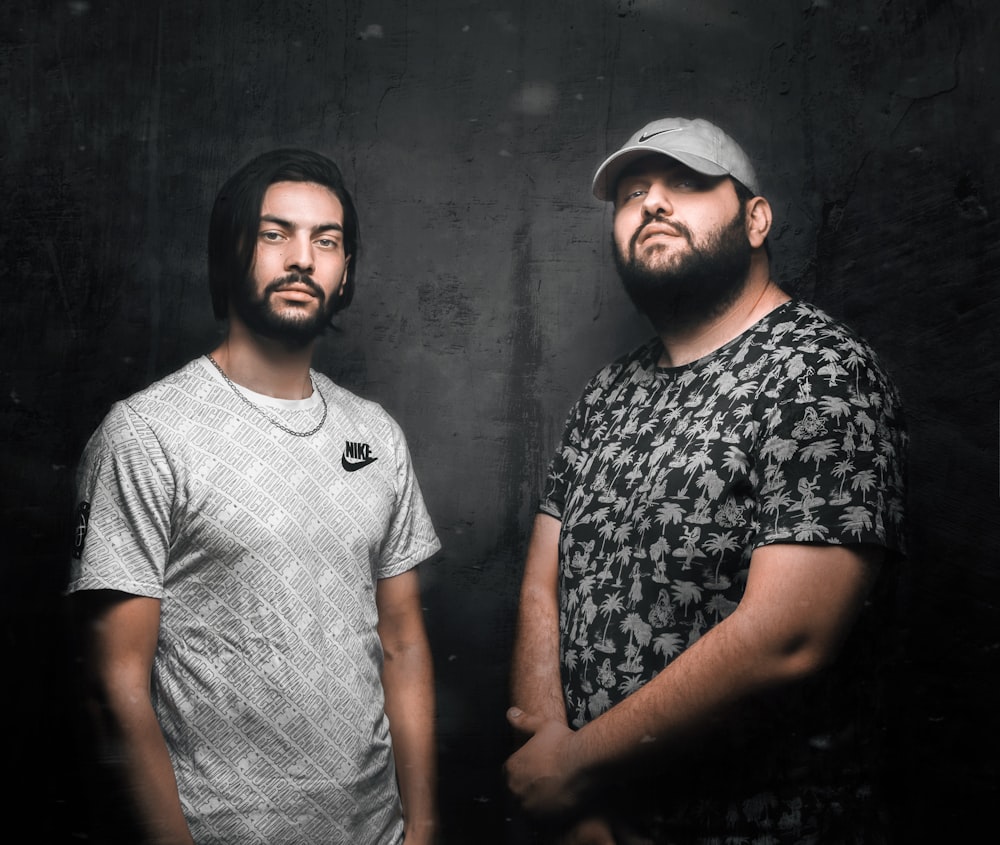 man in white and black crew neck t-shirt standing beside man in white and black