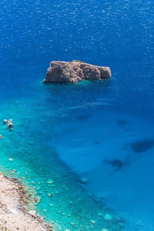 brown rock formation on blue sea water during daytime in Amorgos Greece