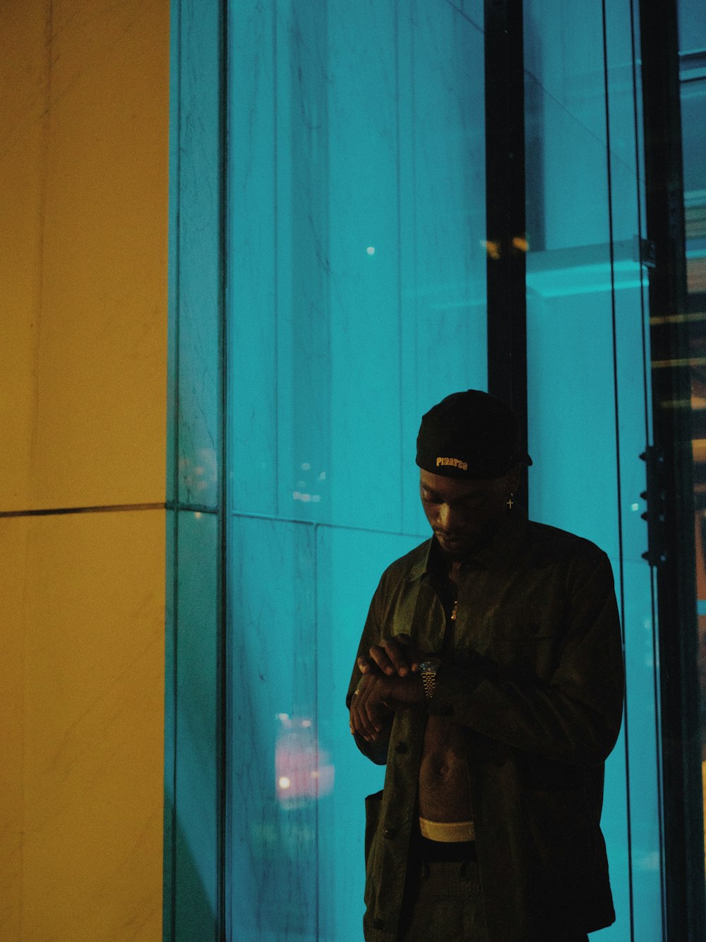 Mann in schwarzer Jacke in der Nähe der Glaswand
