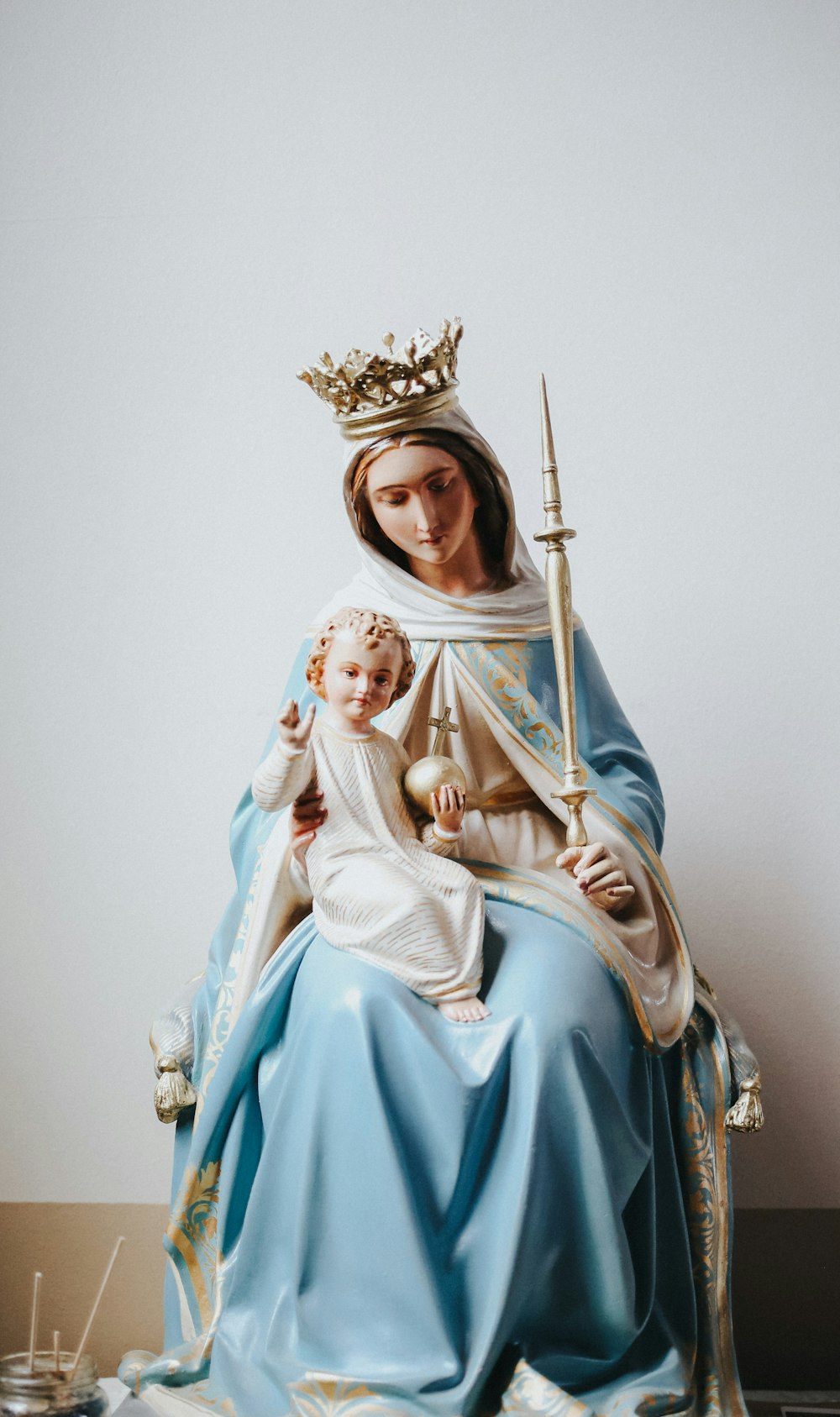 woman in blue dress holding baby figurine