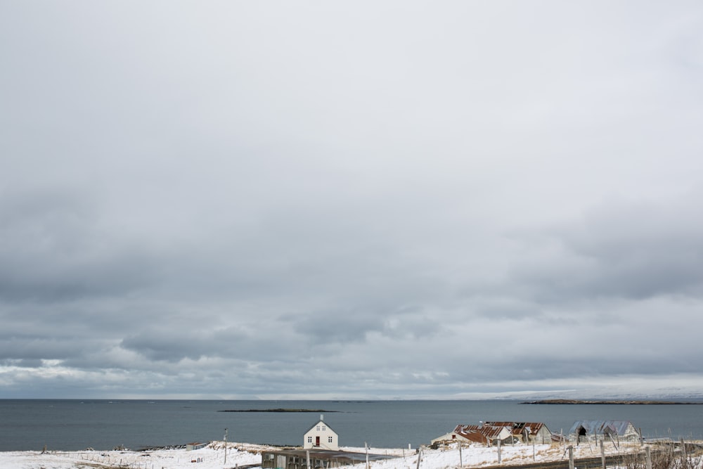 white and brown houses on beach under gray cloudy sky during daytime