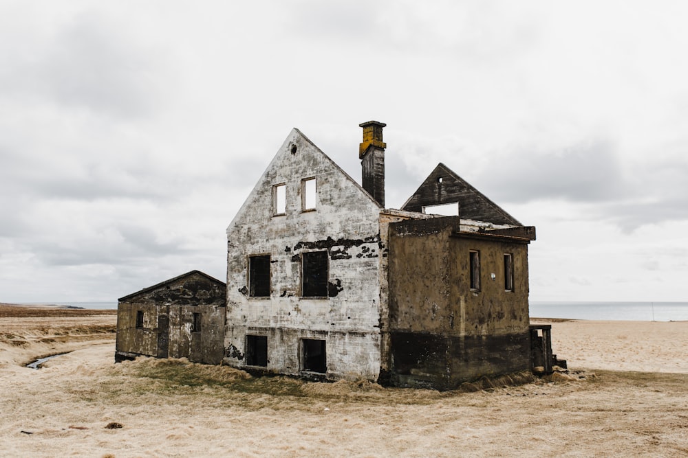 Weißes und graues Betonhaus tagsüber unter weißen Wolken