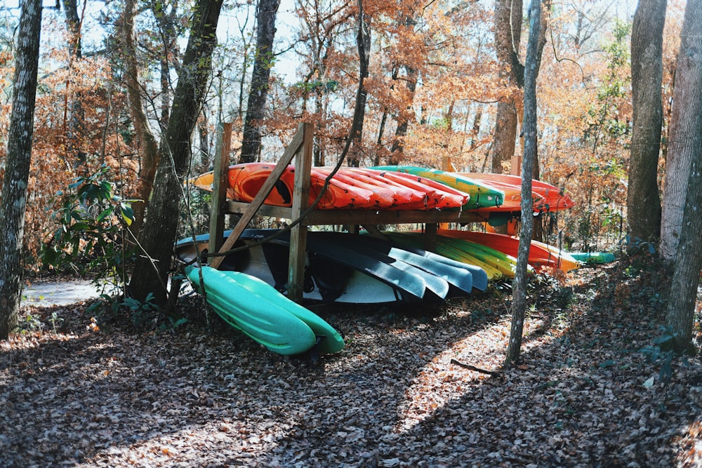 green kayak on brown soil near brown wooden bridge