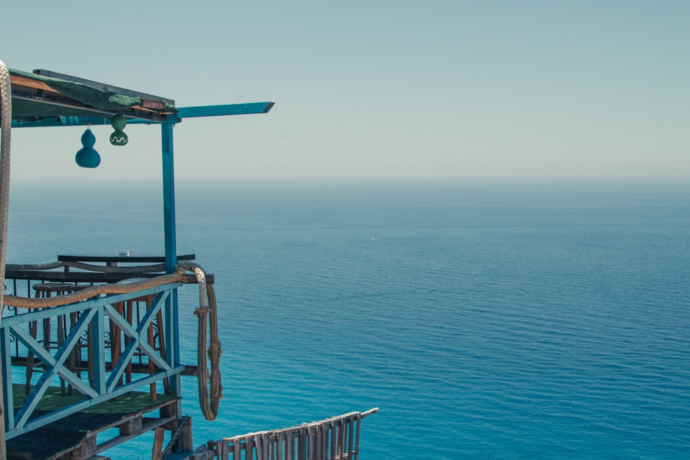 Torre de salvavidas de madera azul y marrón en el mar azul durante el día