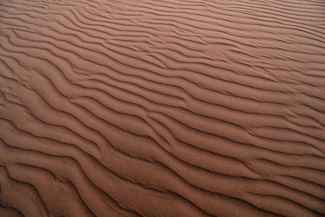 brown sand with shadow of person,