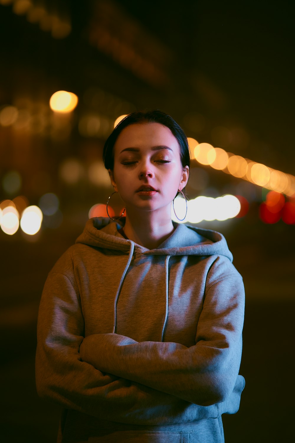 woman in gray hoodie wearing white earbuds