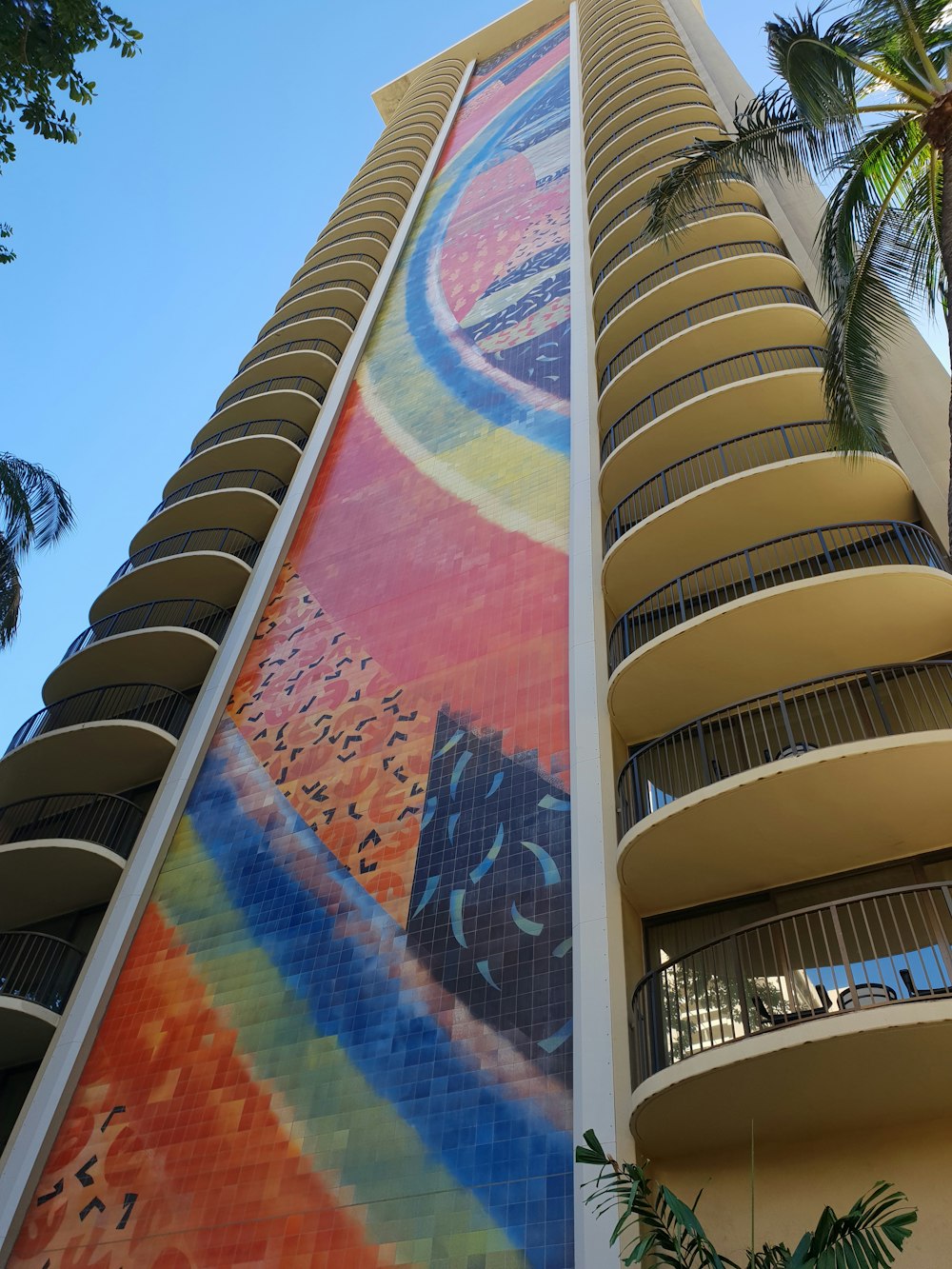 white concrete building with multi color wall art during daytime