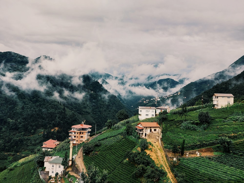 edificio de hormigón blanco y marrón en un campo de hierba verde bajo nubes blancas durante el día