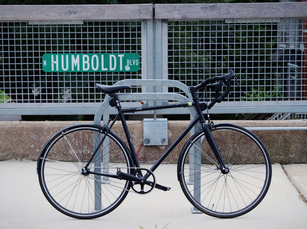 black city bike parked beside the wall