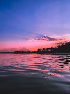 A serene landscape at sunset with vibrant colors in the sky.