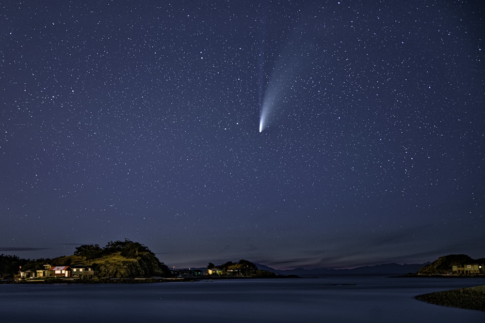 brown and green mountain beside body of water during night time