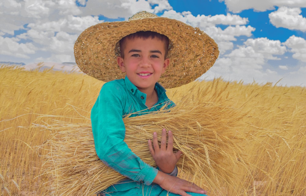 woman in blue long sleeve shirt wearing brown straw hat standing on brown wheat field during