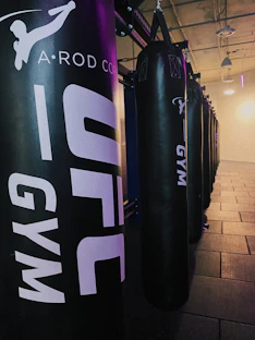 A modern, stylish gym corner with fuchsia accents and boxing gloves neatly arranged.