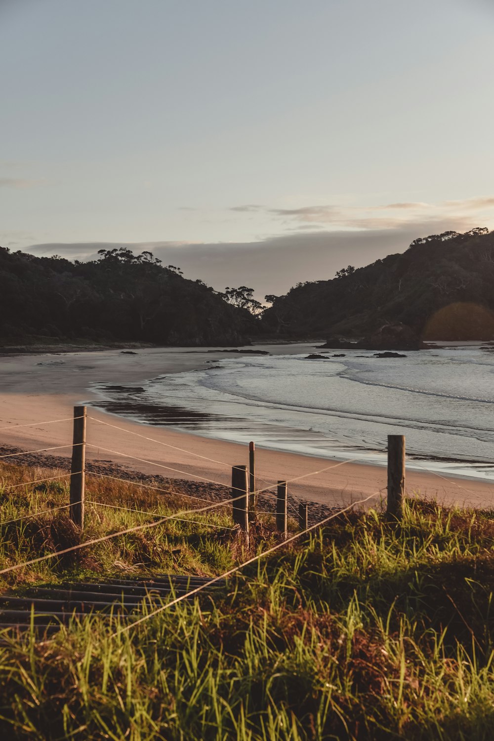 brown wooden fence near sea during daytime