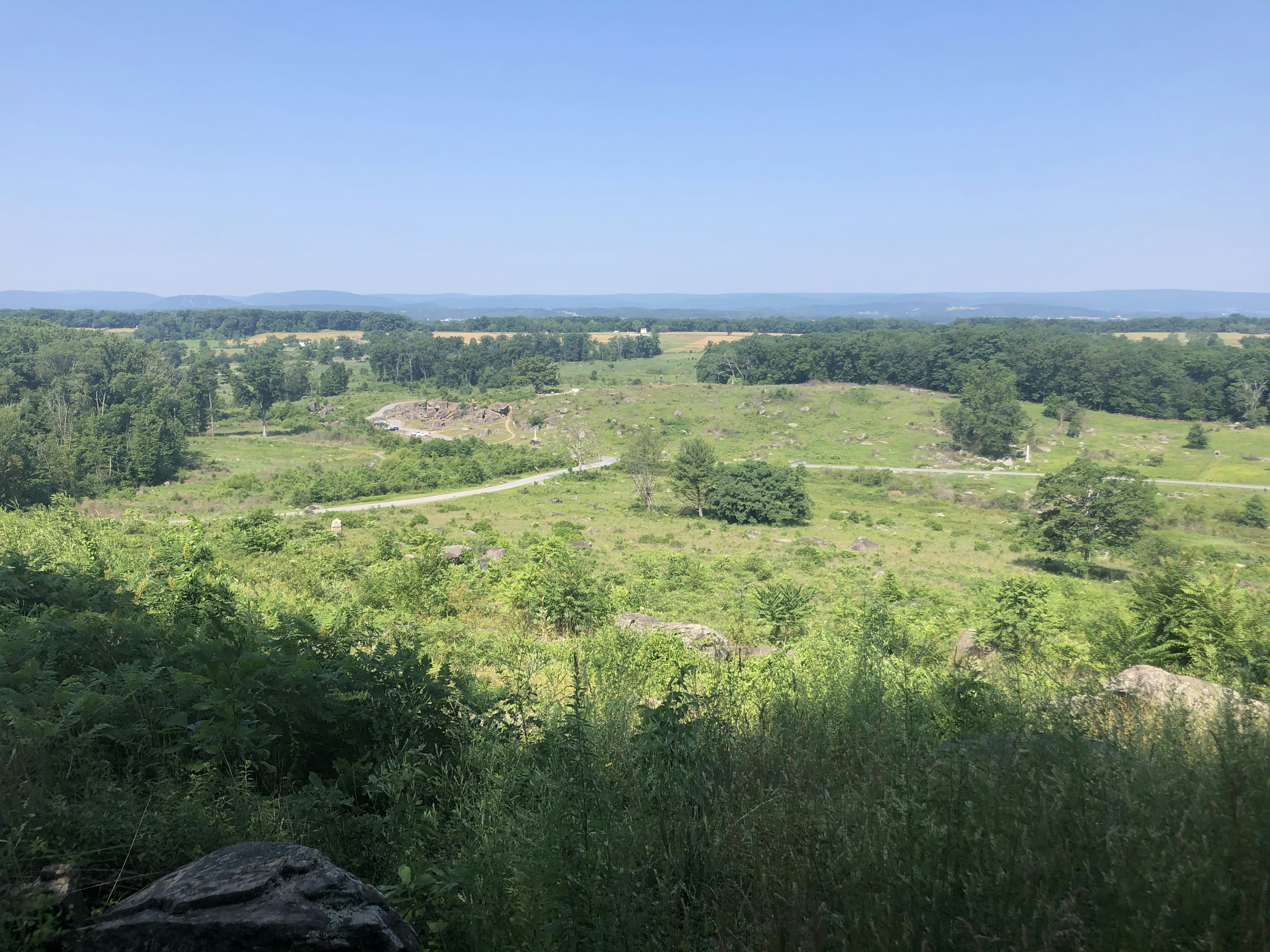 Wide open green rolling hills landscape, bright sunny open sky, airy natural daylight, expansive visibility