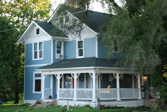 white and gray wooden house near green trees during daytime