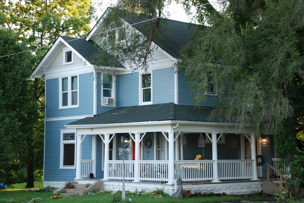 white and gray wooden house near green trees during daytime