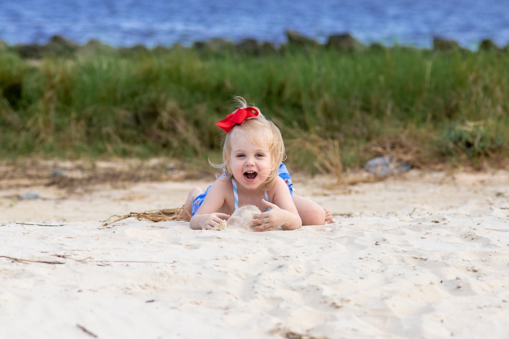 girl in red headband sitting on sand during daytime