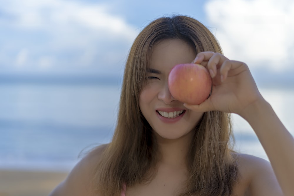 woman holding pink egg during daytime