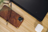 High-end phone resting on a wooden desk next to tech accessories.