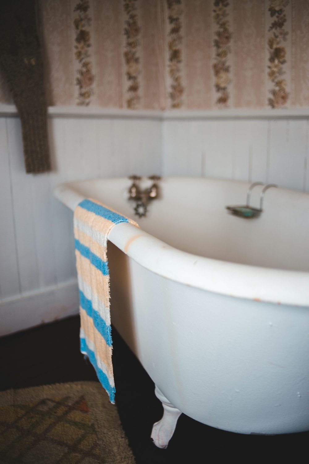 white ceramic bathtub with blue and white checked towel