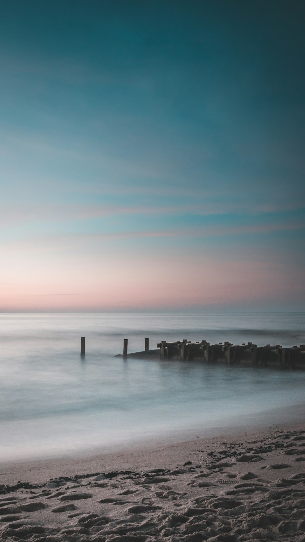 brown wooden dock on sea during sunset