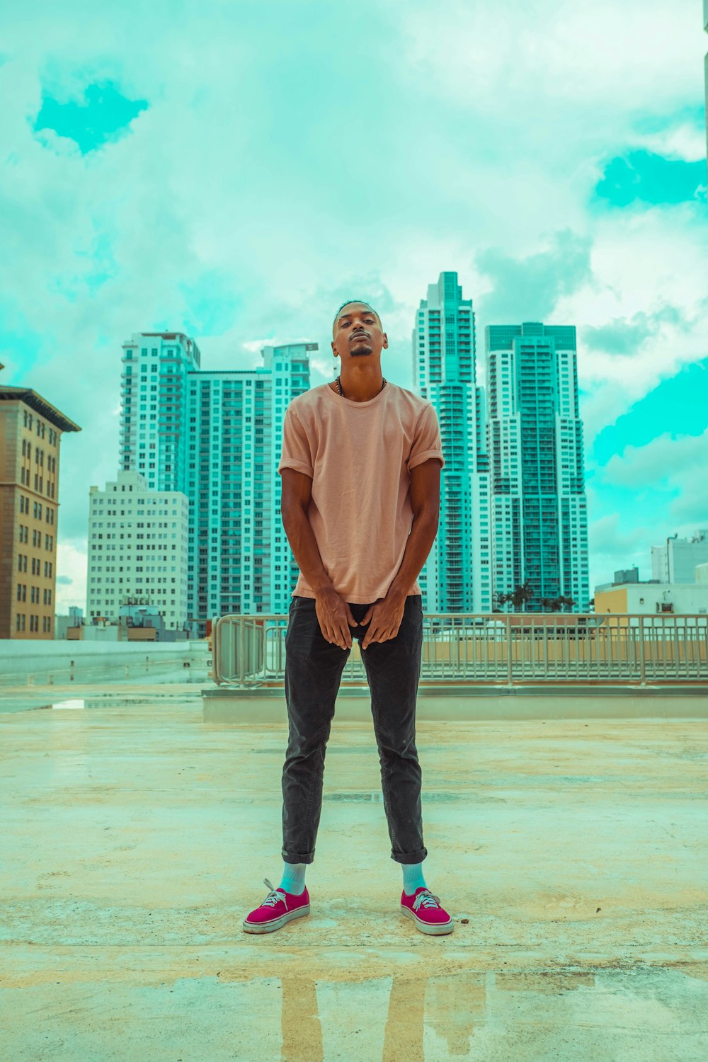 man in white long sleeve shirt and black pants standing on gray concrete floor during daytime