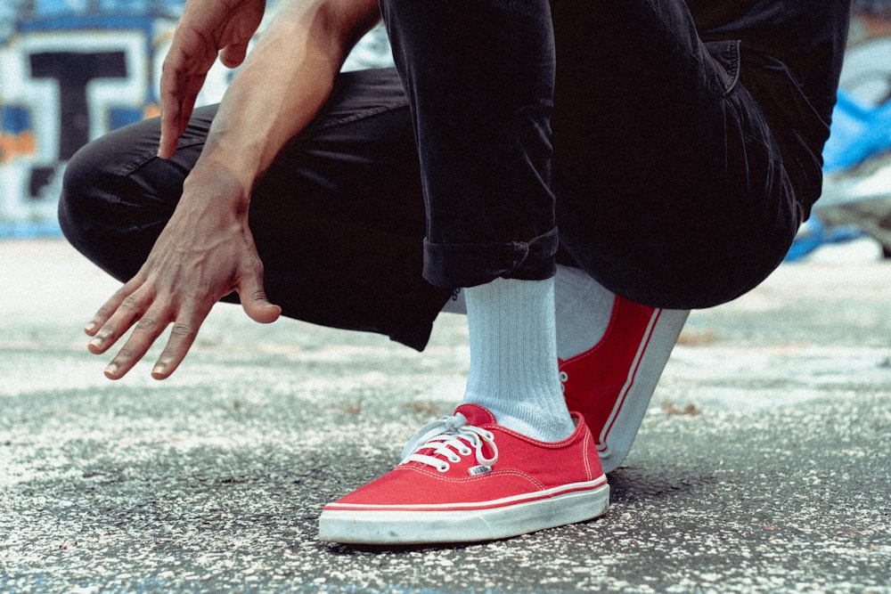 person in black pants and red sneakers