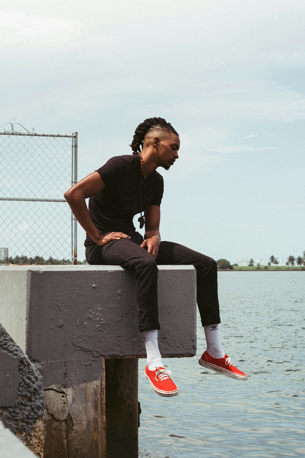 man in black crew neck t-shirt sitting on gray concrete bench